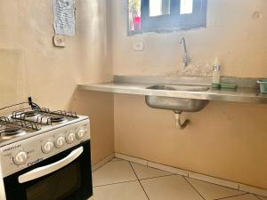 a kitchen with a stove and a sink at Hostel Mar in São Luís