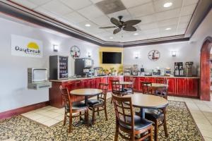 a restaurant with tables and chairs and a kitchen at Days Inn by Wyndham Pearl/Jackson Airport in Pearl