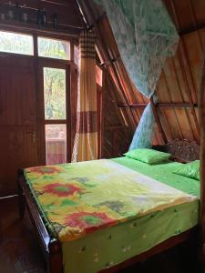a bedroom with a bed in a room with a window at Ella Rock Lodge in Ella