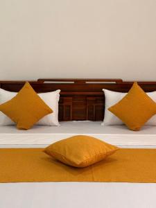 a bed with four pillows on top of it at Chara Bloom Hotel in Dickwella