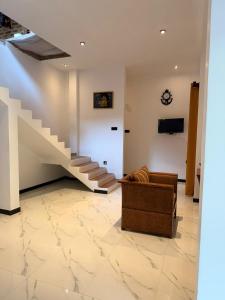 a living room with a staircase and a couch at Chara Bloom Hotel in Dickwella