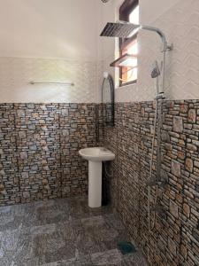 a bathroom with a sink and a shower at Chara Bloom Hotel in Dickwella +16 photos