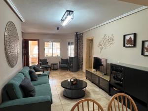 a living room with a green couch and a tv at Casa Noel in Ciudad Quesada