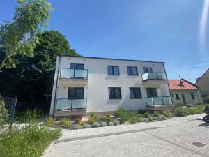 a white building with balconies on the side of it at Apartman Alex in Liptovský Mikuláš