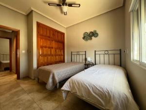 a bedroom with two beds and a ceiling fan at Casa Noel in Ciudad Quesada +32 photos