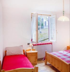 a bedroom with two beds and a window at Ca' Maria - Casa in Scalve in Schilpario