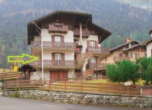 a large building with wooden balconies on a mountain at Ca' Maria - Casa in Scalve in Schilpario