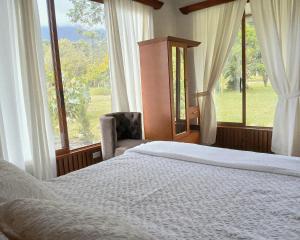 a bedroom with a bed and a large window at La Quinta de Andrés in San Isidro