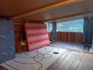 a room with a red chair and a large window at BTR Farm in Da Ðeum (2)