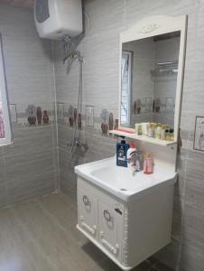 a bathroom with a white sink and a mirror at BTR Farm in Da Ðeum (2)