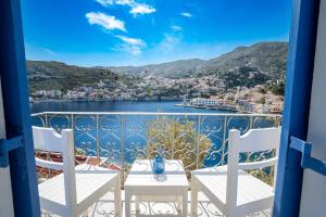 Blick von einem Balkon mit Tisch und Stühlen in der Unterkunft Artiki's Studios - Sea & Harbour View Apartments in Symi in Symi