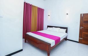 a bedroom with a bed with colorful curtains at Yala Lemon View in Tissamaharama +18 photos