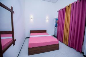 a room with two beds and colorful curtains at Yala Lemon View in Tissamaharama
