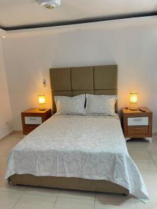 a bedroom with a large bed with two night stands at Villas Carela, Villas Privadas con Piscina y Jacuzzi a 2 Minutos de la Playa de Cabarete in Cabarete +44 photos