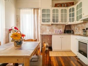 a kitchen with white cabinets and a wooden table at Acropol Seaview Apartment in Corfu Old Town by the Old Port in Corfu +24 photos