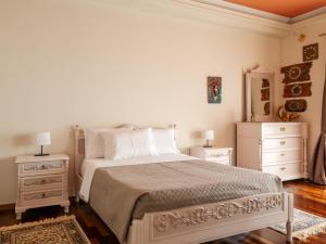 a white bedroom with a bed and two night stands at Acropol Seaview Apartment in Corfu Old Town by the Old Port in Corfu