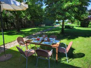 een tafel en stoelen in een tuin met een paraplu bij Belvilla by OYO Camillo Tosco in Valiano