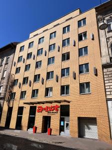 a large brick building with a synergy sign on it at AMISTAT Hub Hostel Budapest in Budapest