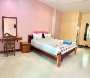 a bedroom with a bed and a chair and a mirror at สายป่านอาพาร์ทเม้นท์ in Ban Bung Sam Phan Nok