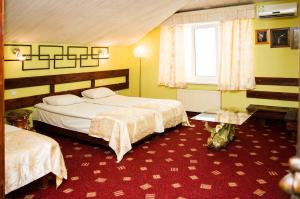 um quarto de hotel com duas camas e uma janela em Guest House De Rishelye em Odessa
