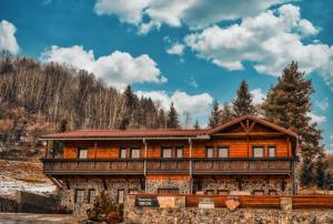 a log cabin in the mountains with snow on the ground at Penzión Hron - Beňuš in Beňuš