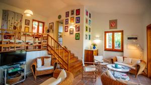 a living room with a staircase and chairs and a table at Villa Averla-Costa Paradiso, con giardino vista graniti e mare in Costa Paradiso