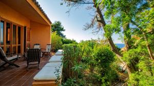 a porch of a house with a view of the ocean at Villa Averla-Costa Paradiso, con giardino vista graniti e mare in Costa Paradiso