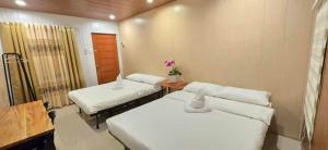a room with two beds and a table with flowers at Kasyatel in Impasugong