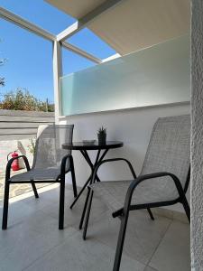 a patio with two chairs and a table on a balcony at Fiosal Apartments 2 in Skiathos +15 photos