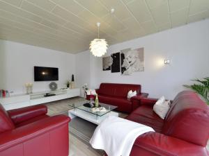 ein Wohnzimmer mit roten Sofas und einem TV in der Unterkunft Flat in Bruchhausen with private terrace in Bruchhausen