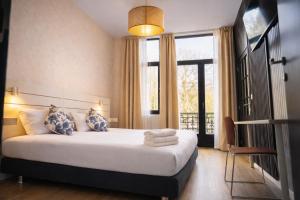 a bedroom with a bed and a large window at Hotel Le Centenaire Brussels Expo in Brussels