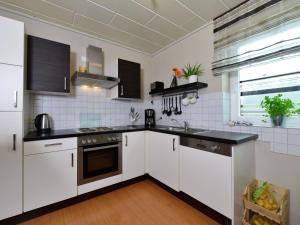 eine Küche mit weißen Schränken und schwarzen Arbeitsplatten in der Unterkunft Flat in Bruchhausen with private terrace in Bruchhausen