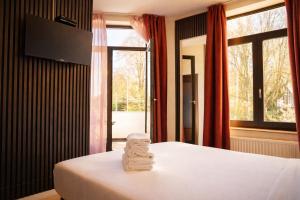 a bedroom with a bed with two folded towels on it at Hotel Le Centenaire Brussels Expo in Brussels