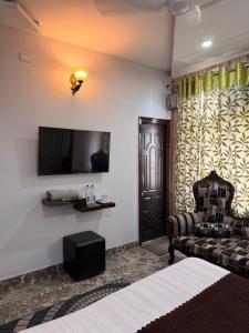 a living room with a couch and a flat screen tv at Pacific Grand in Amritsar