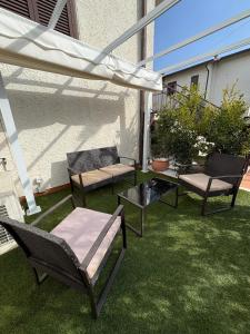 a patio with two chairs and a table and an umbrella at Capalbio Relaxhouse in Capalbio