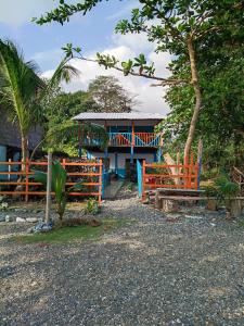 a house with a fence in front of it at Casa hostal playa coral in Capurganá