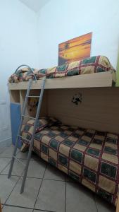 a bunk bed with a ladder next to a bunk bedouble at Casa Danero "U dabassu" - Centro storico di Carloforte in Carloforte
