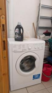 a washing machine with a detergent bottle on top of it at Casa Danero "U dabassu" - Centro storico di Carloforte in Carloforte