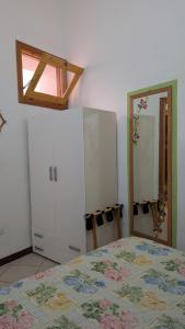 a bedroom with a bed and a dresser and a mirror at Casa Danero "U dabassu" - Centro storico di Carloforte in Carloforte +2 photos