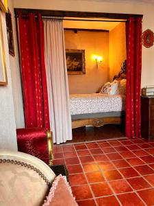 a bedroom with a bed with red curtains and a chair at La Clé de la Porte Rentals in Antibes