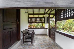 a porch with two chairs and a door at Karanda Eco Resort in Dambulla