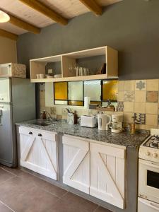 a kitchen with white cabinets and a counter top at Color Local Cabañas in San Javier