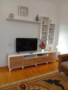 a large entertainment center with a flat screen tv in a living room at Shahdag Beloved Home in Qusar