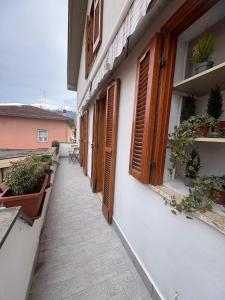 a corridor of a building with wooden doors and plants at A casa di Maria in Sulmona