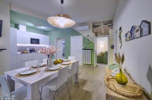 a kitchen and dining room with a white table and chairs at Daniel House - Lake and ferry terminal 1 minute walk, in the heart of Bellano in Bellano