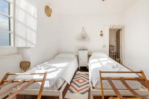 two beds in a room with two chairs and a window at Casa Anita - Storia & Mare in Zoagli