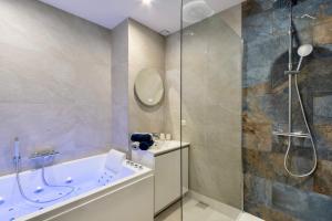 a bathroom with a tub and a shower at L'escale Mourillon - Plage, Balnéo & Soleil in Toulon