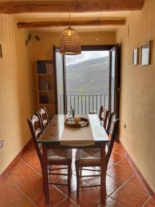 a dining room with a table and chairs and a window at Capileira Luz de Sierra in Capileira