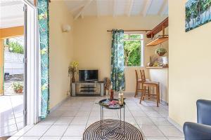 a living room with a tv and a table at Gîte Dalina Sainte-Rose in Sainte-Rose