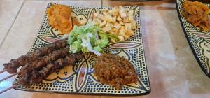 a plate of food with meat and vegetables and chips at Kasbah Ait ben Damiette in Skoura